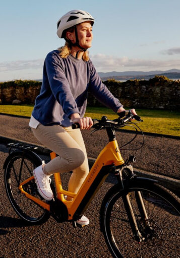 Hände schlafen beim Radfahren ein: Frau fährt auf gelbem E-Bike(314)