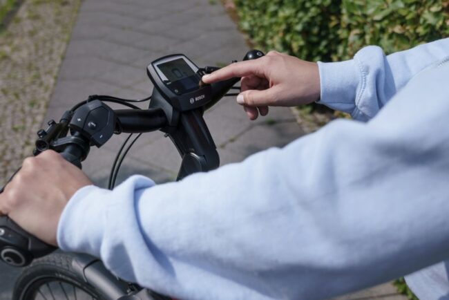 Kalorienverbrauch E-Bike: Frau bedient ihren Fahrradcomputer