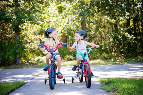 Fahrradtour mit Kindern: Mädchen fahren Fahrrad mit Stützrädern